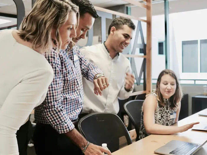 Group of professionals working together and discussing ideas in a bright modern office setting